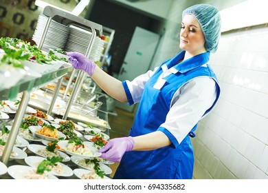 buffet female worker servicing food in cafeteria - Shutterstock ID 694335682
