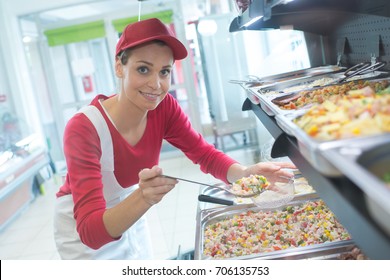 Buffet Female Worker Servicing Food In Cafeteria