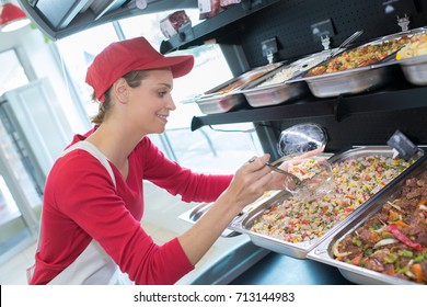 Buffet Female Worker Servicing Food In Cafeteria