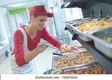 Buffet Female Worker Servicing Food In Cafeteria