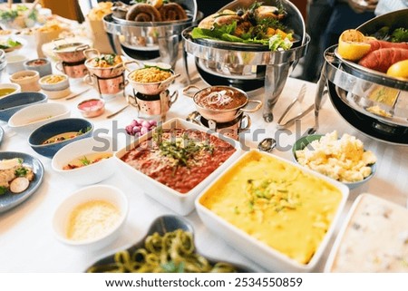 Buffet table with diverse dishes, including salads, meats, and desserts. Various cuisines displayed in bowls, offering a variety of flavors and textures. Buffet table with international food dishes.