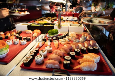 Buffett dinner. Hands picking up Sushi and fish specialties in buffett dinner at luxury hotel. Food concept.