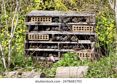 A bug house made of pallets and pinecones.