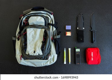 Bug Out Bag Emergency Items Against A Black Background Survival Concept