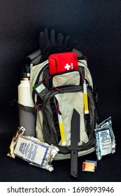 Bug Out Bag Emergency Items Against A Black Background Survival Concept