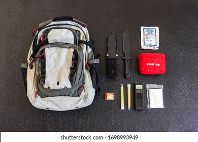 Bug Out Bag Emergency Items Against A Black Background Survival Concept