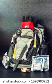 Bug Out Bag Emergency Items Against A Black Background Survival Concept