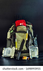 Bug Out Bag Emergency Items Against A Black Background Survival Concept