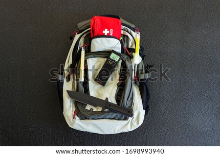 Bug Out Bag Emergency Items Against a Black Background Survival Concept