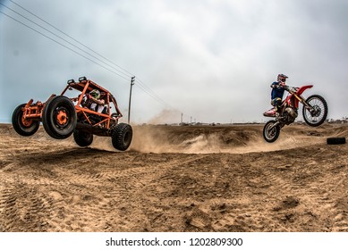 Buggy and orange motocross jumping the mountain at the same time. the concept of power and force speed.
