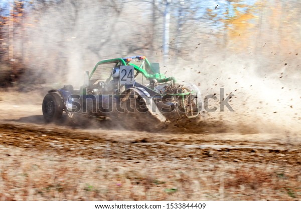 Buggy racing. Mud splashes from wheels. Motion\
blurred background