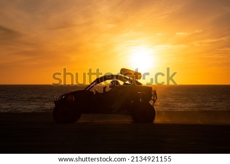 Buggy running at the beach at sunset