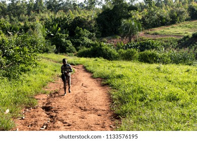 Buikwe, Uganda. 5 June 2017. A Boy Walking Alone On A Path In A Rural Landscape.