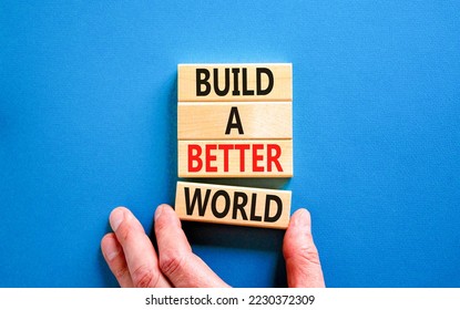 Build a better world symbol. Concept words Build a better world on wooden cubes. Beautiful blue table blue background. Businessman hand. Business build a better world concept. Copy space. - Shutterstock ID 2230372309