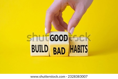 Build Good or Bad Habits symbol. Businessman hand turns wooden cubes and changes the words Build Bad Habits to Build good Habits. Beautiful yellow background. Business concept. Copy space