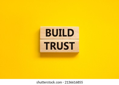 Build trust symbol. Concept words Build trust on wooden blocks on a beautiful yellow table yellow background. Business and build trust concept, copy space.