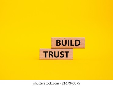 Build trust symbol. Wooden blocks with words Build trust. Beautiful yellow background. Business and Build trust concept. Copy space. Conceptual image