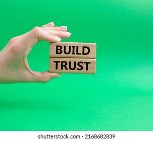 Build trust symbol. Wooden blocks with words Build trust. Beautiful green background. Businessman hand. Business and Build trust concept. Copy space.. Conceptual image