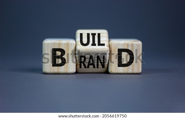 Build your brand symbol.\
Turned wooden cubes and changed the word \'build\' to \'brand\'.\
Beautiful grey background. Build your brand and business concept.\
Copy space.