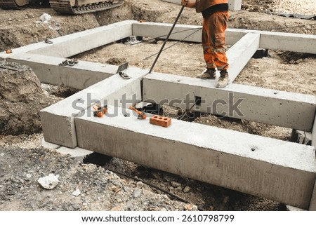 Builder assembling foundation made of pre-cast concrete beams