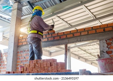 Builder Carefully Puts Red Brick On The Masonry. Quick Work Bricklayer. Guy Measures Level Masonry. Man Is Building Brick Wall. Correctly Calculate Material. Builder Manually Carries Brick Structure,B