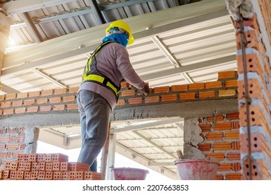 Builder Carefully Puts Red Brick On The Masonry. Quick Work Bricklayer. Guy Measures Level Masonry. Man Is Building Brick Wall. Correctly Calculate Material. Builder Manually Carries Brick Structure,B