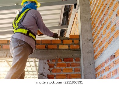 Builder Carefully Puts Red Brick On The Masonry. Quick Work Bricklayer. Guy Measures Level Masonry. Man Is Building Brick Wall. Correctly Calculate Material. Builder Manually Carries Brick Structure,B