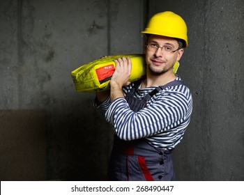 Builder carry bag with cement on his shoulder 