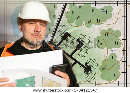 Builder is considering a plan terrain. Topographic plan area. Concept - Development of topographical plans. Planning and development of cities. Builder holds paper with plans in his hands. Architect