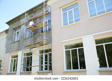 Builder contractor plastering external walls before painting outside house facade. Prepare for painting house exterior walls. - Shutterstock ID 2226142601