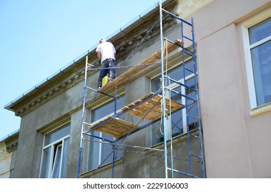 Builder contractor plastering external walls before painting outside house facade. Prepare for painting house exterior walls. - Shutterstock ID 2229106003