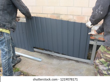 Builder contractors  installing metal sheets for waterproofing and protect from rain  house foundation wall.