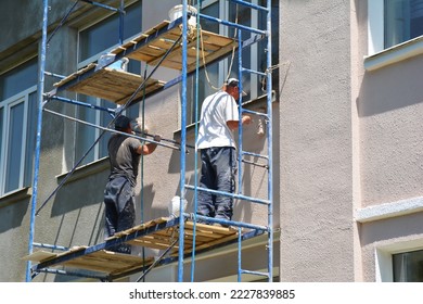 Builder contractors painting external walls outside house facade. Close up on painting house outside wall. - Shutterstock ID 2227839885