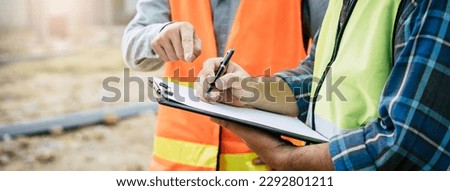Builder engineer and supervisor consultant inspection job plan  concept, Asian contractor and foreman looking blueprint in computer laptop and checking process plan of factory warehouse construction