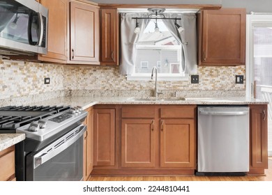 Builder Grade Kitchen with Oak Shaker Cabinets and Stainless Steel Appliances. Basic Kitchen in rental apartment.