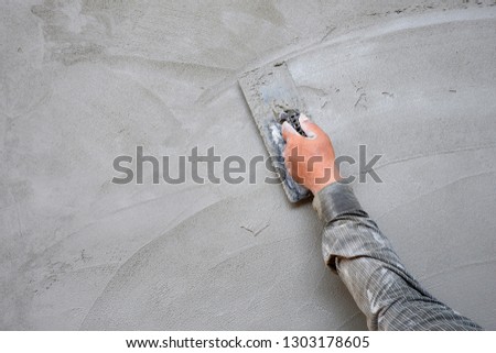 Builder Hand using wooden Trowel to Plastering Cement Wall in Construction Site