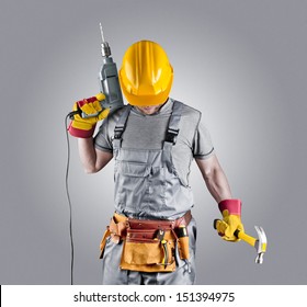 Builder In A Helmet With A Hammer And A Drill