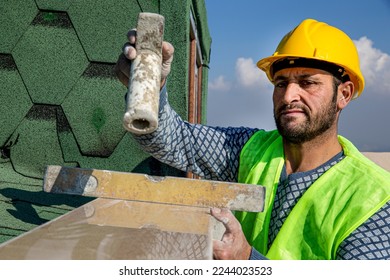 The builder is hitting the marble with a hammer and leveling it with a spirit level. The master replaces a polished marble handrail. - Shutterstock ID 2244023523
