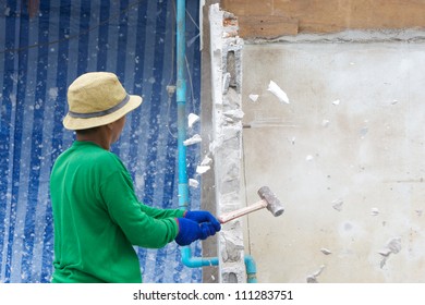 Builder Hitting A Wall With A Sledge Hammer