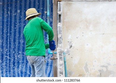 Builder Hitting A Wall With A Sledge Hammer