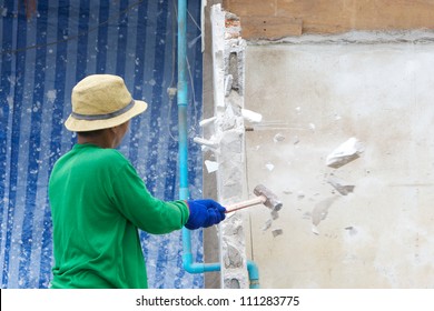 Builder Hitting A Wall With A Sledge Hammer