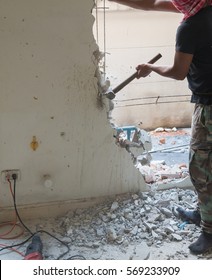 Builder Hitting A Wall With A Sledge Hammer