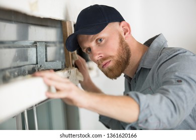 Builder Inspectiing Damaged Window Lintel