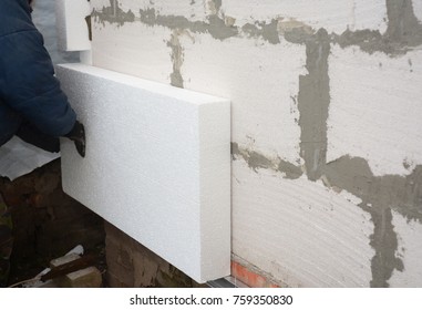 Builder installing rigid styrofoam insulation board for energy saving. Rigid extruded polystyrene insulation.