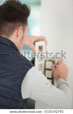 builder installing a triple lightswitch