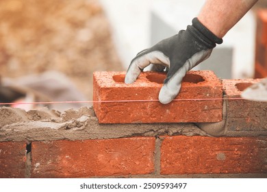 Builder Laying Bricks in Masonry Project at Construction Site During Daylight Hours