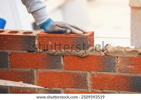 Builder Laying Bricks on a Construction Site During Daylight Hours