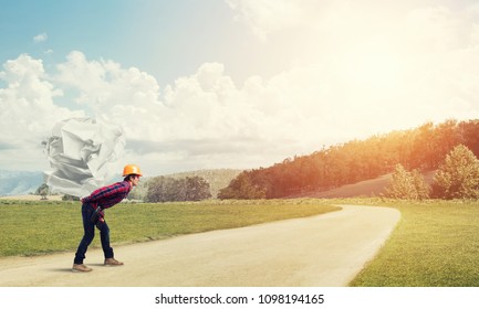 Builder man carrying paper ball on his back - Shutterstock ID 1098194165