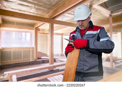 Builder Man. Guy Works On Wood. Builder Prepares Wood House Parquet. Foreman With Ruler. Concept Finishing House With Wood Siding. House Facade Cladding With Siding. Man Builder During Work.