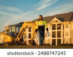 Builder on excavator. Builder worker with excavator. Builder in helmet. Worker in hardhat. Portrait mechanical worker in construction helmet. Engineer builder foreman or repairman.